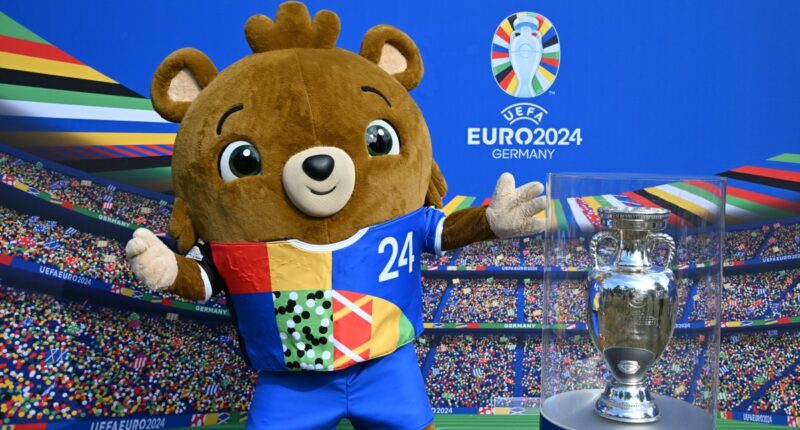 Eurocopa: Albaert, la mascota del Campeonato Europeo de Fútbol UEFA Euro 2024, posa junto a una maqueta del trofeo durante un evento promocional el 24 de mayo de 2024 en Berlín. (Foto por RALF HIRSCHBERGER / AFP)