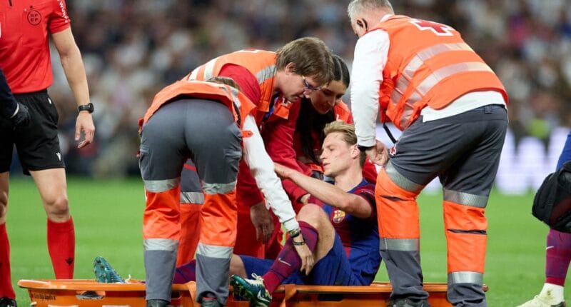 Frenkie de Jong del FC Barcelona está siendo colocado en una camilla después de sufrir una lesión durante el partido LaLiga EA Sports entre el Real Madrid CF y el FC Barcelona en el Estadio Santiago Bernabeu de Madrid, España, el 21 de abril de 2024.